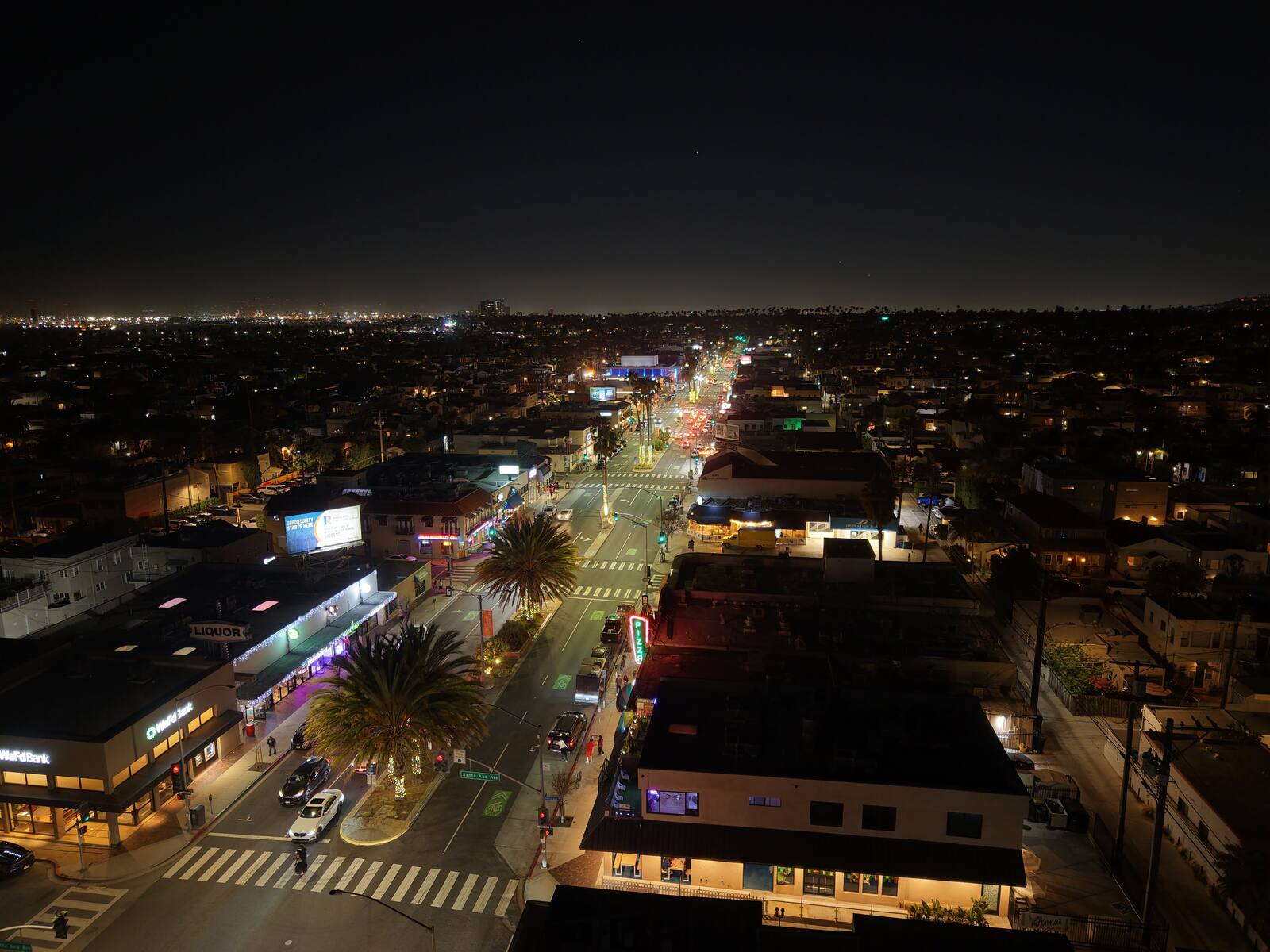 2nd Street Belmont Shore at night — aerial view looking along the commercial strip with neon signs and city lights