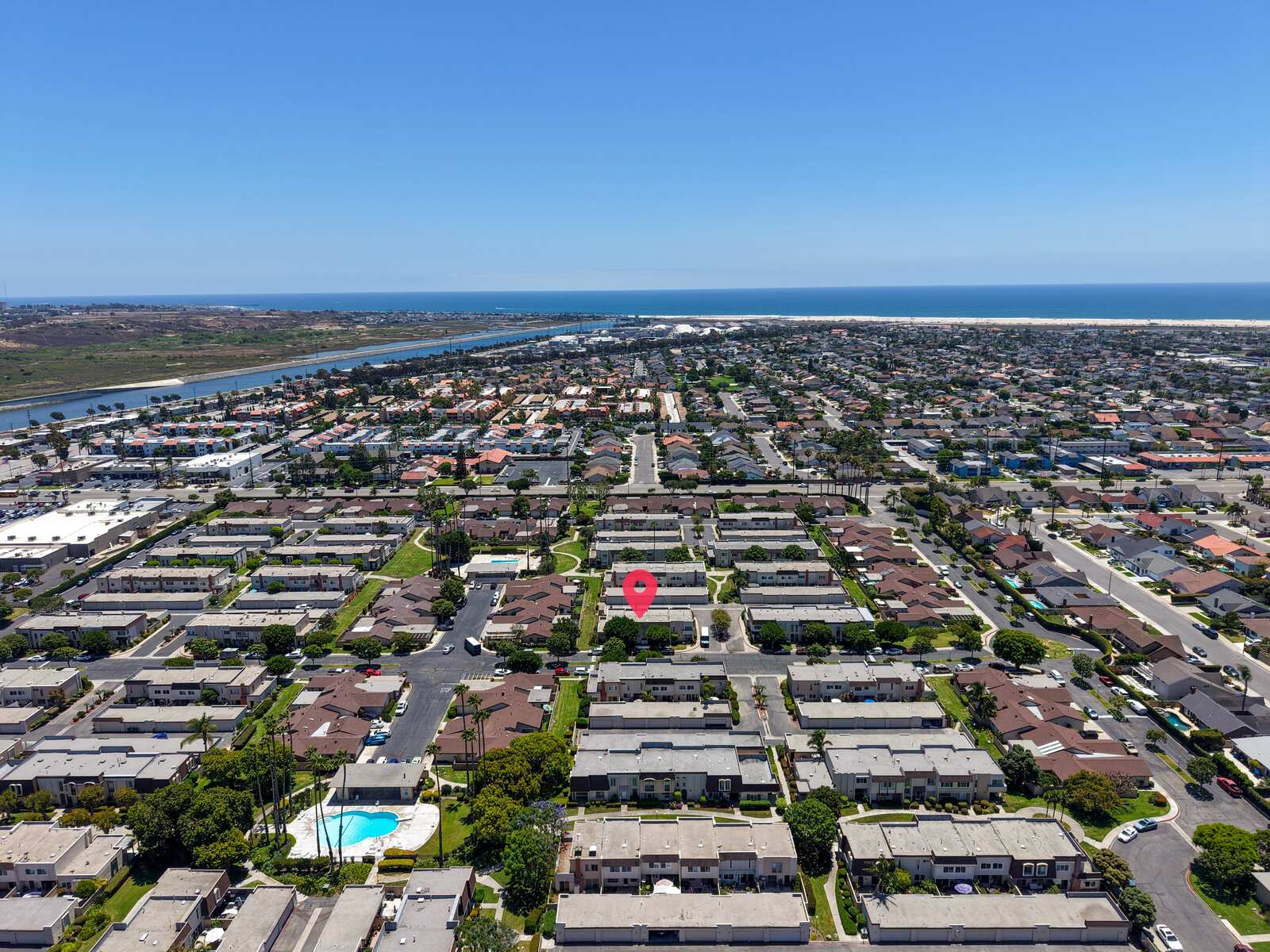 Villa Pacific listing — aerial view of a Huntington Beach residential community with ocean visible in the background